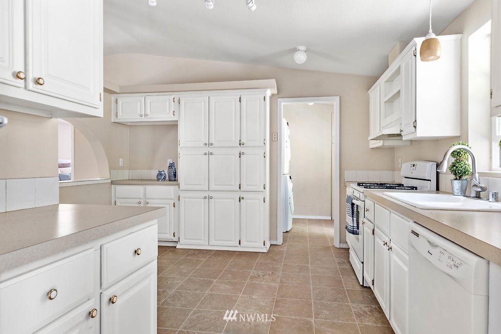 1815 Newman Road Freeland, WA 98249 - Photo 10 of 26 a kitchen with white cabinets and sink