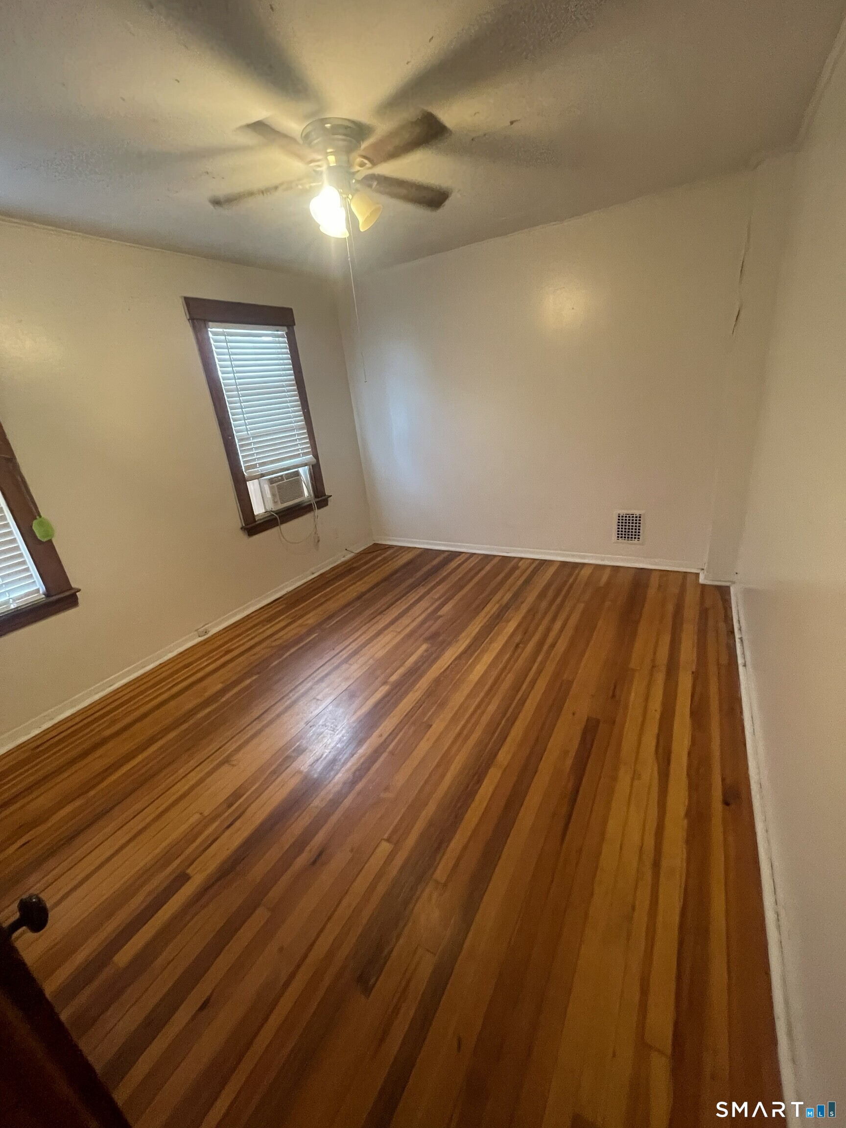 65 1st Street, Unit 2 Hamden, CT 06514 - Photo 10 of 15 an empty room with wooden floor fan and windows