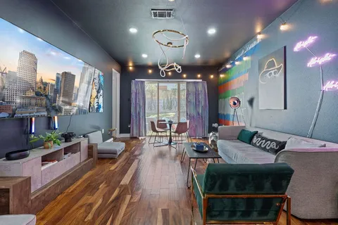 a living room with furniture a large window and a chandelier