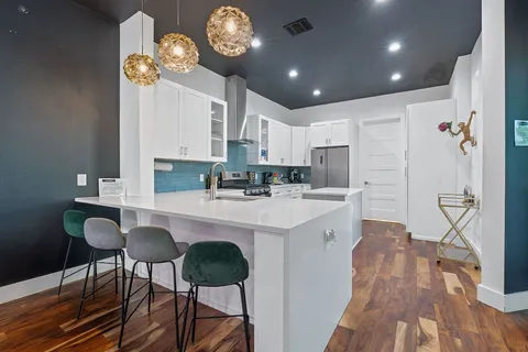 a kitchen with stainless steel appliances granite countertop a stove refrigerator and cabinets