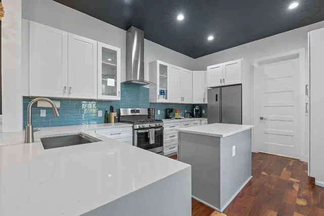 a kitchen with stainless steel appliances granite countertop a lot of counter space and wooden floors