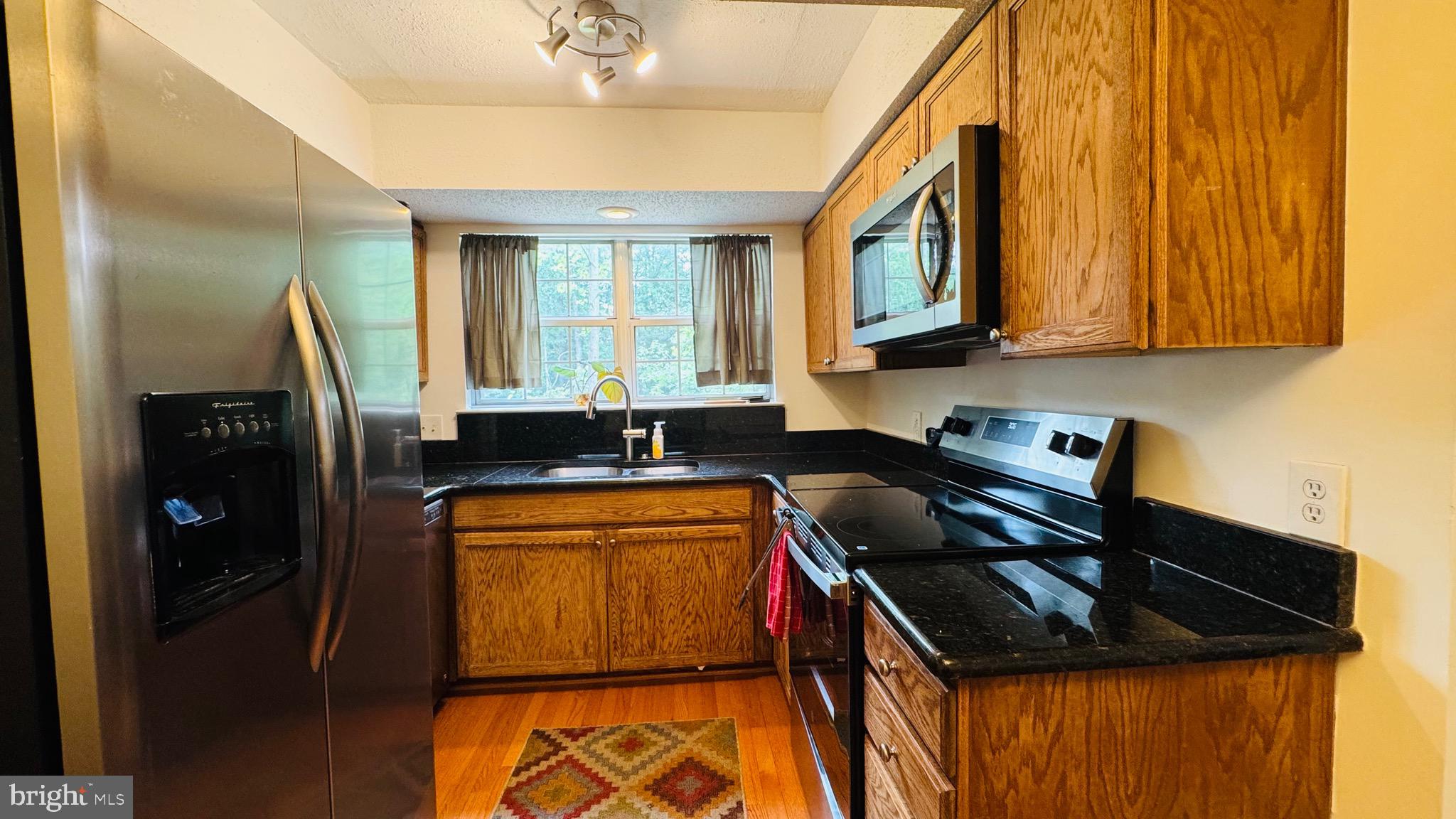 12012 Golf Ridge Court, Unit 374 Fairfax, VA 22033 - Photo 6 of 38 a kitchen that has a sink and a stove in it