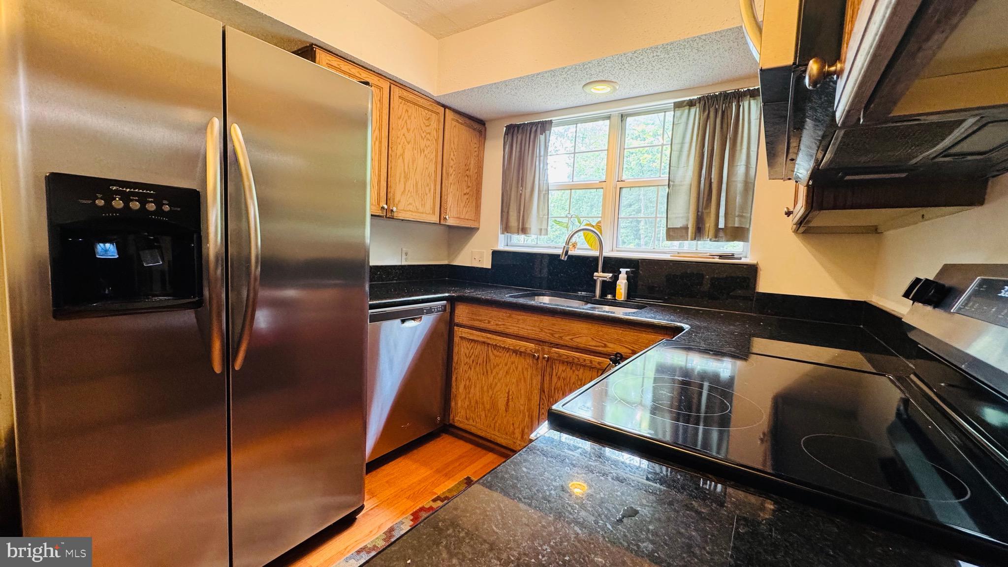 12012 Golf Ridge Court, Unit 374 Fairfax, VA 22033 - Photo 7 of 38 a kitchen with stainless steel appliances granite countertop a refrigerator and a sink