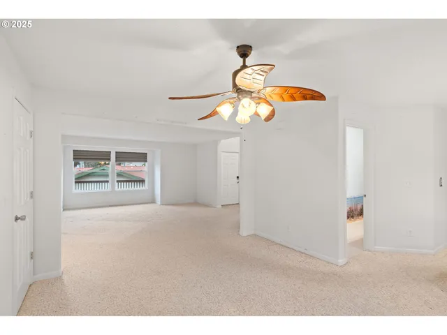 a view of a room with a ceiling fan and window