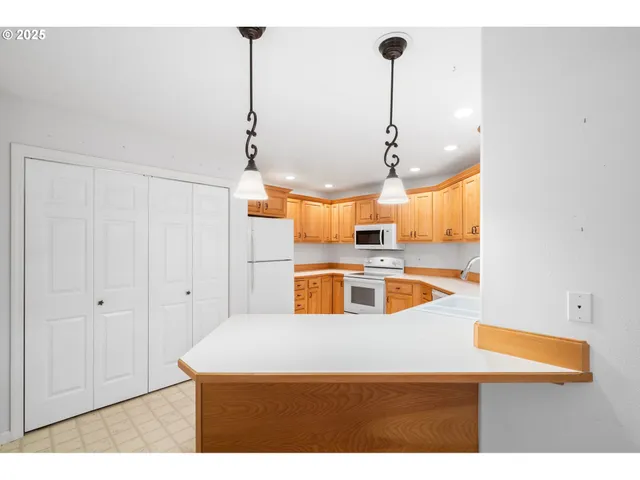 a kitchen with stainless steel appliances granite countertop a sink a stove and a refrigerator