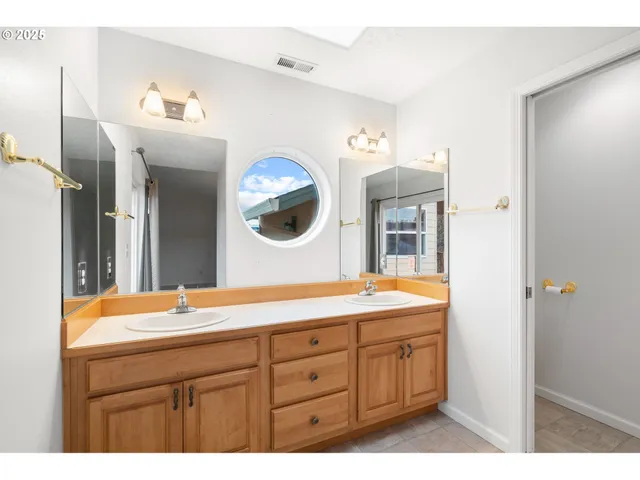 a bathroom with a granite countertop sink mirror vanity and toilet
