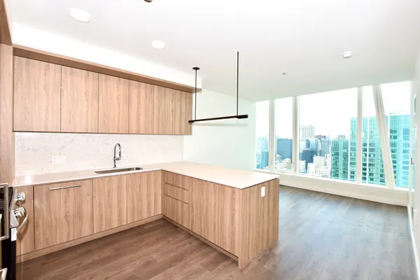 a kitchen with a sink a window and wooden floor