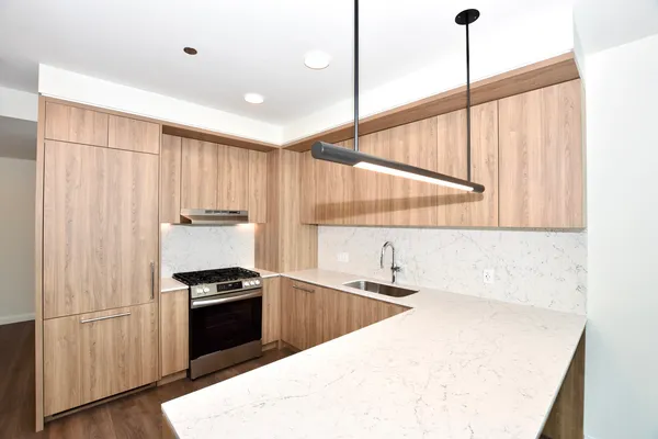 a kitchen with stainless steel appliances granite countertop a sink a stove and a refrigerator