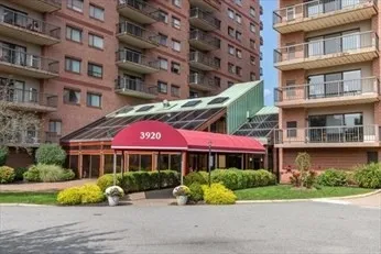 a front view of an apartment building with a yard and plants
