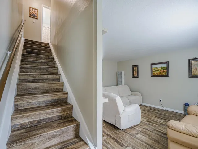 a kitchen with stainless steel appliances a refrigerator a stove a sink and white cabinets with wooden floor