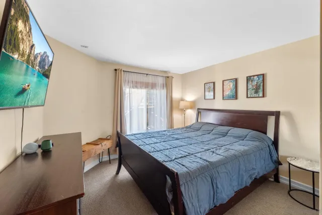 a bedroom with a bed and a dresser next to a window