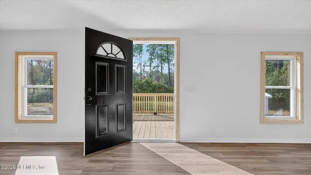 a view of empty room with wooden floor and fireplace