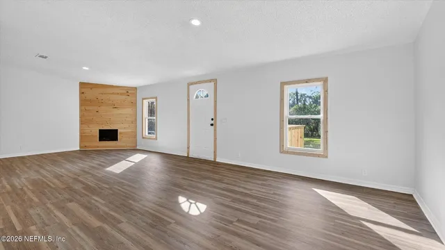 a view of an empty room with wooden floor