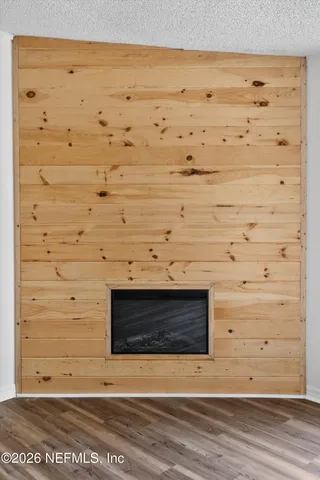 a view of a kitchen with wooden floor and a fireplace