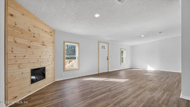 a kitchen with stainless steel appliances granite countertop a refrigerator a sink dishwasher a stove and white cabinets with wooden floor