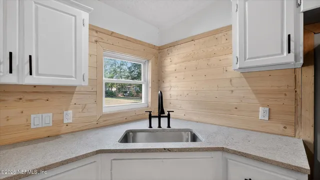 a kitchen with kitchen island white cabinets and stainless steel appliances