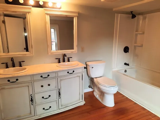 a bathroom with a sink a toilet and shower