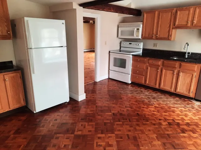 a kitchen with granite countertop a refrigerator stove a sink and dishwasher
