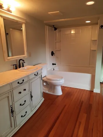 a bathroom with a bathtub sink mirror and toilet