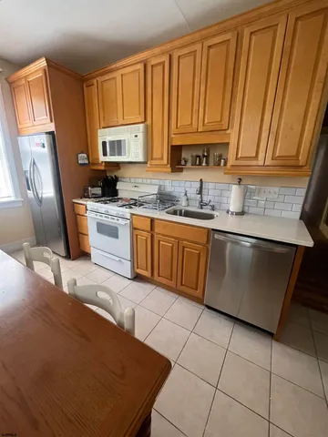 a kitchen with stainless steel appliances granite countertop a sink stove refrigerator and cabinets