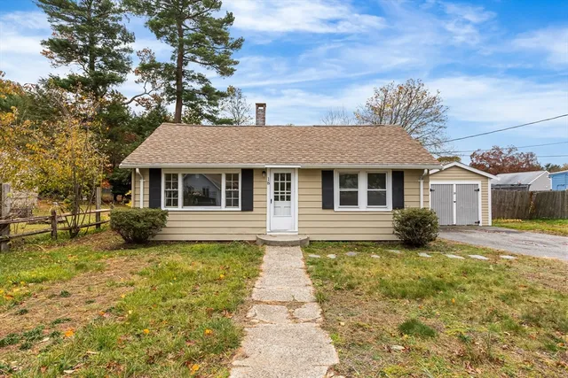 a view of a house with a large tree in the yard