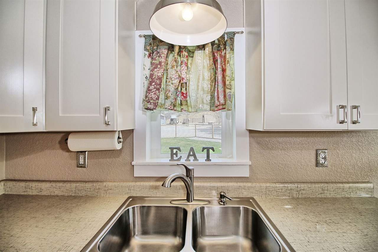 1302-17 17 1/2 Road Fruita, CO 81521 - Photo 19 of 39 a kitchen with stainless steel appliances granite countertop a sink and a white cabinets with a granite countertops