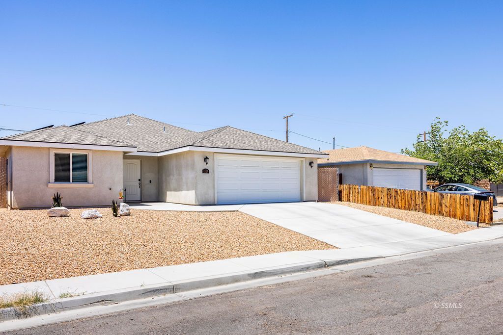 1229 South Ranger Street Ridgecrest, CA 93555 - Photo 2 of 36 a front view of a house with a yard and a garage
