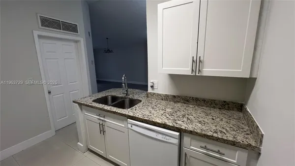 a kitchen with granite countertop white cabinets and a stove