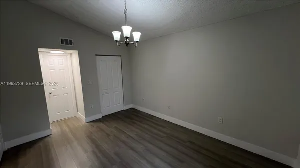 a view of an empty room with wooden floor