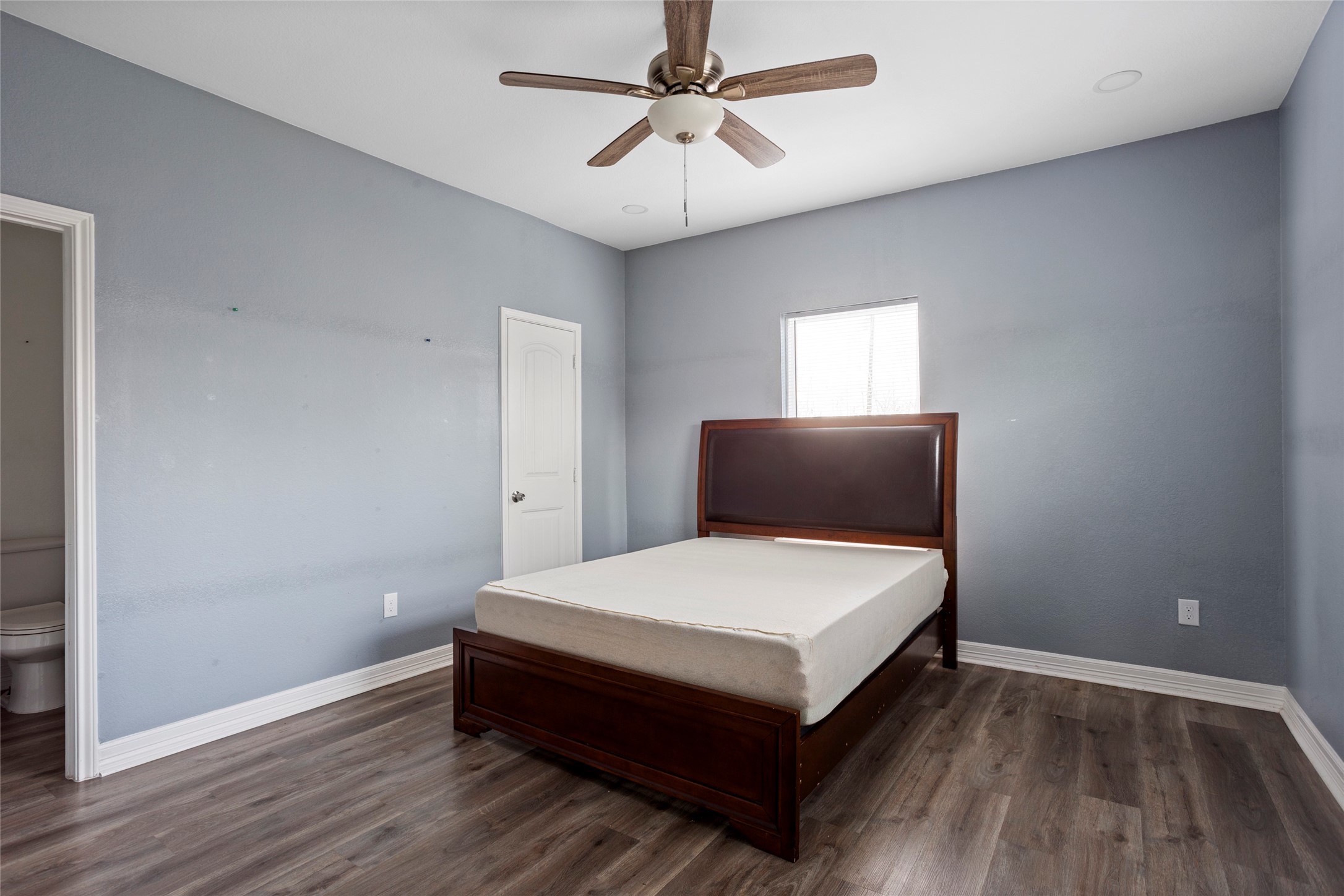 9814 Masterson Street Houston, TX 77029 - Photo 10 of 21 a bedroom with a bed and a chandelier