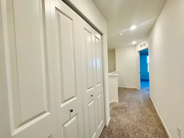 a view of a hallway with wooden shelves