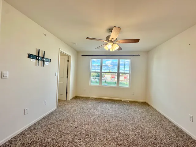 an empty room with a window and a fan