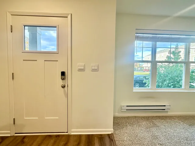 a view of a small space with wooden floor and a window