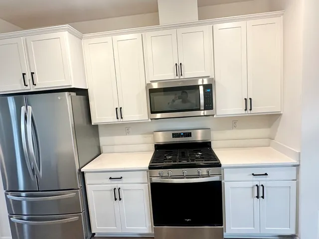 a kitchen with cabinets stainless steel appliances and a window