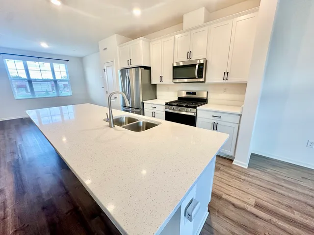 a kitchen with kitchen island a stove a sink and a microwave