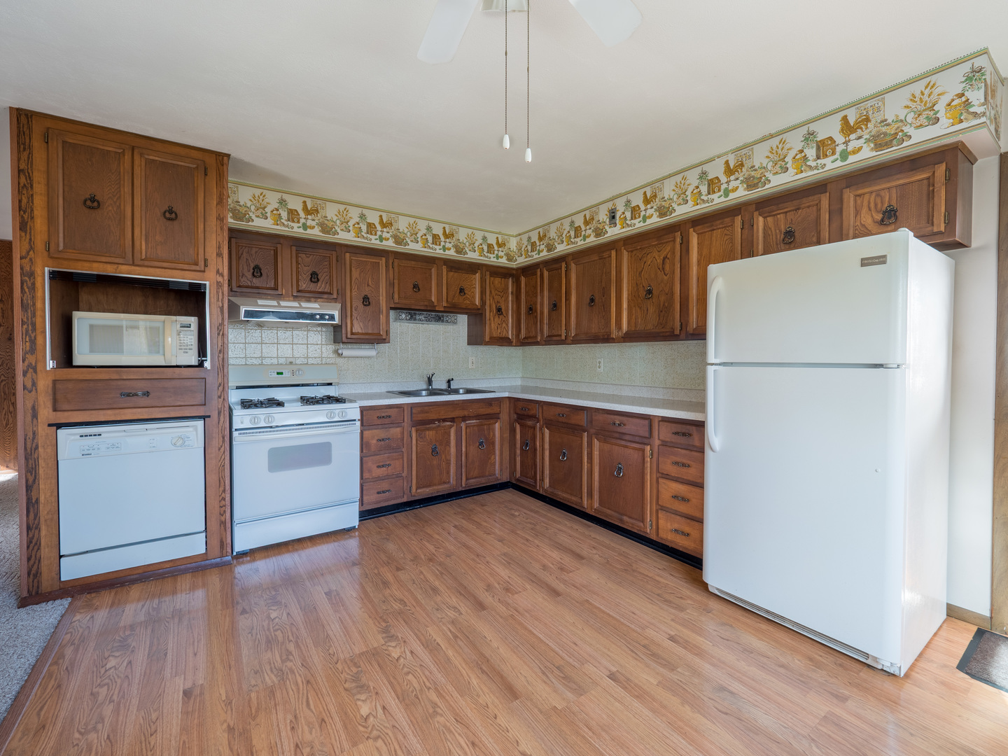 615 Best Avenue DeKalb, IL 60115 - Photo 7 of 12 a kitchen with wooden floors and white appliances