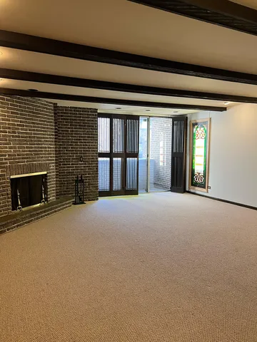 a view of a fireplace and window in an empty room