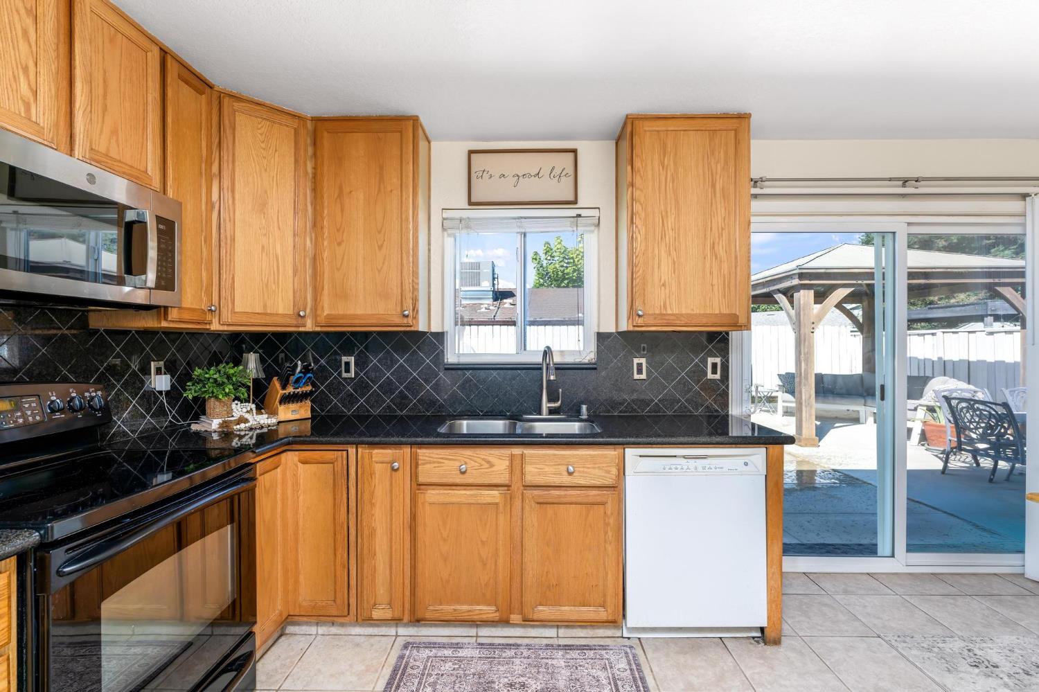731 Dixie Lane Ripon, CA 95366 - Photo 5 of 22 a kitchen with stainless steel appliances granite countertop a stove a sink and a microwave