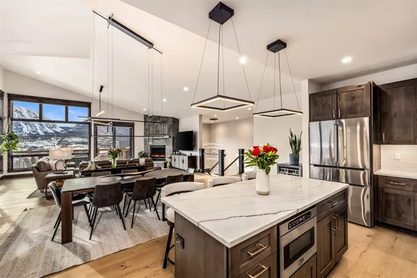 a kitchen with stainless steel appliances granite countertop a table chairs and a refrigerator