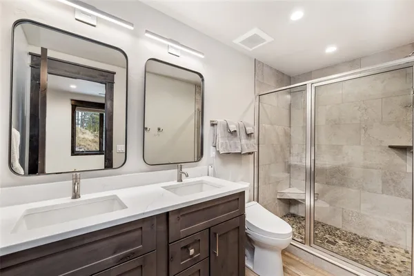 a bathroom with a double vanity sink mirror and toilet