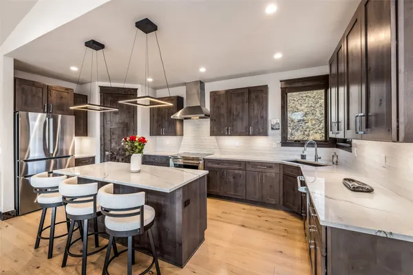 a kitchen with kitchen island granite countertop a sink stove and refrigerator