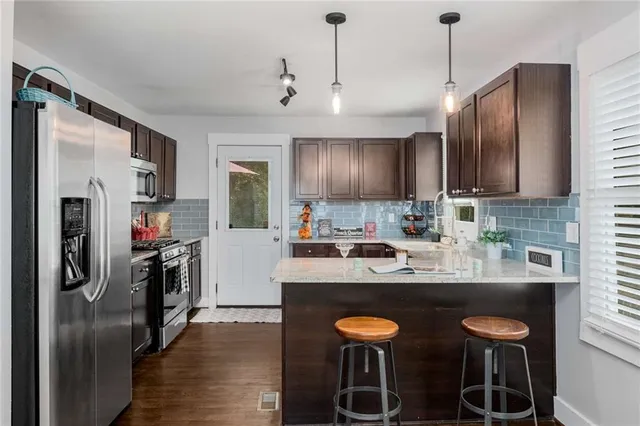 a kitchen with granite countertop wooden cabinets a stove a sink and a oven
