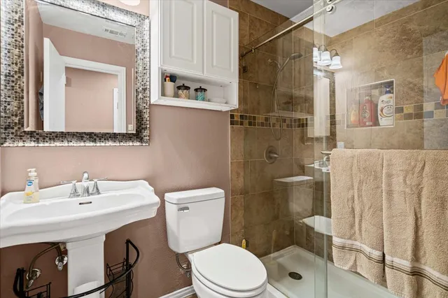 a bathroom with a sink a toilet and shower