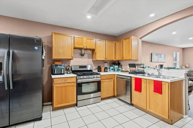 a kitchen with stainless steel appliances granite countertop a stove a sink dishwasher and a refrigerator