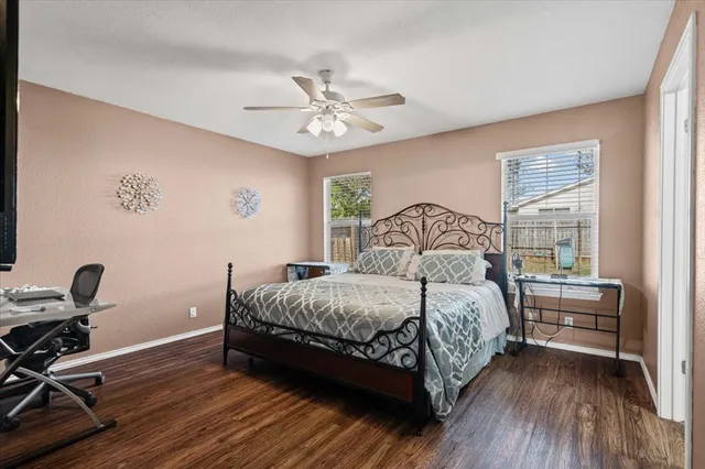 a bedroom with a bed wooden floor and window