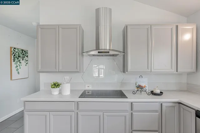 a large white kitchen with chairs a sink and cabinets