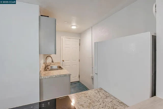 a kitchen with a refrigerator sink and cabinets