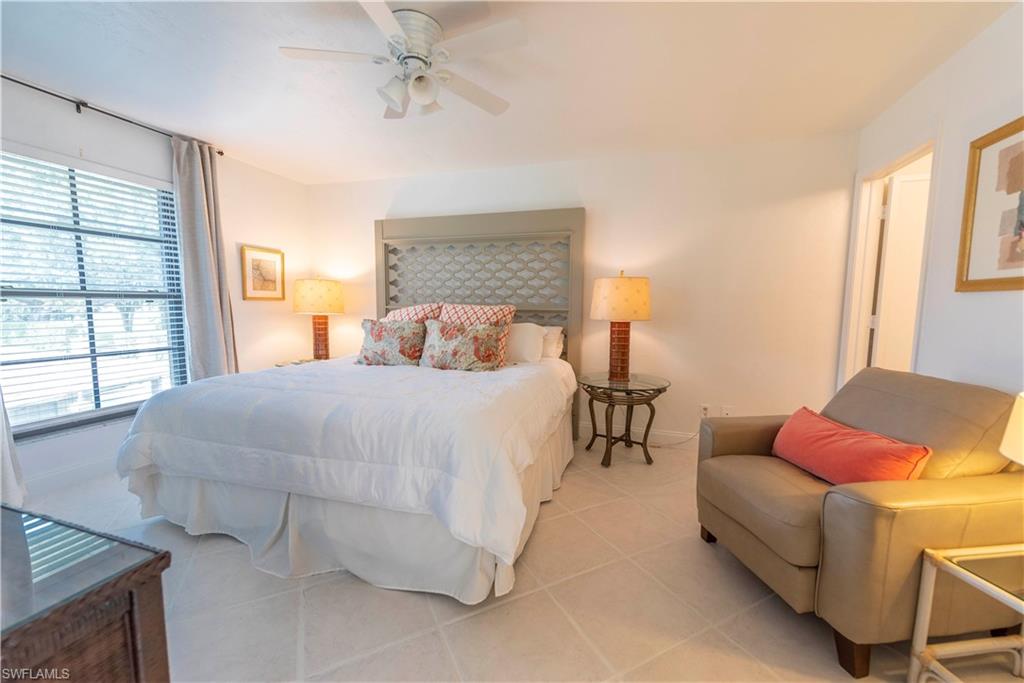 3107 Riviera Drive, Unit A202 Naples, FL 34103 - Photo 12 of 25 a bedroom with a bed and a couch