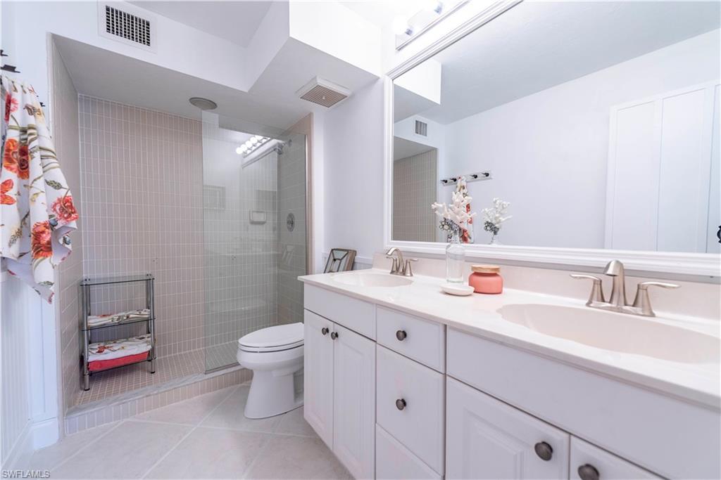 3107 Riviera Drive, Unit A202 Naples, FL 34103 - Photo 14 of 25 a bathroom with a sink and a mirror