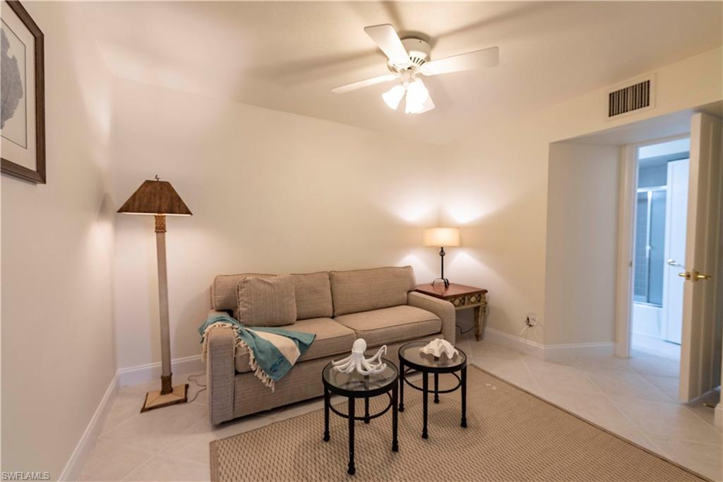 3107 Riviera Drive, Unit A202 Naples, FL 34103 - Photo 17 of 25 a living room with furniture and a lamp